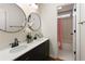 Bathroom featuring double sinks, large round mirrors, and doorway view of a shower with pink curtain at 2275 Barrett Dr, Cumming, GA 30040