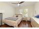 Comfortable bedroom with hardwood floors, dresser, ceiling fan, and large window with natural light at 2275 Barrett Dr, Cumming, GA 30040