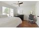 Bright bedroom featuring hardwood floors, ceiling fan, and a large window for lots of natural light at 2275 Barrett Dr, Cumming, GA 30040