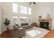 Cozy living room with stone fireplace, tall windows, and comfortable sectional sofa at 2275 Barrett Dr, Cumming, GA 30040