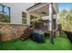Covered back patio with a ceiling fan, stairs down to the synthetic lawn, and a privacy fence at 306 Atley Pl, Alpharetta, GA 30009