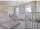 Cozy bedroom with a crib, wallpaper, a chandelier, and two windows at 306 Atley Pl, Alpharetta, GA 30009