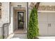 Attractive front door and two-car garage of a brick townhouse with a small tree at 306 Atley Pl, Alpharetta, GA 30009