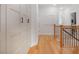 Hallway with wooden floors, white storage cabinets, and railing to stairs at 306 Atley Pl, Alpharetta, GA 30009