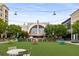 Outdoor space with a green lawn, tables, and string lights in front of Regal Cinemas and surrounding stores in Avalon at 306 Atley Pl, Alpharetta, GA 30009