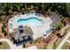 Aerial view of a community pool with ample seating, a pergola, and a clubhouse surrounded by manicured landscaping at 306 Atley Pl, Alpharetta, GA 30009