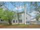 View of the back of house with trees and a fenced backyard with a small patio area at 4845 Weathervane Dr, Alpharetta, GA 30022