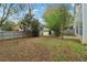 Fenced backyard featuring a storage shed, trees, small patio, and plenty of green space at 4845 Weathervane Dr, Alpharetta, GA 30022