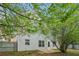 View of the back of house with trees and a fenced backyard with a small patio area at 4845 Weathervane Dr, Alpharetta, GA 30022