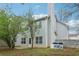 View of the back of house with trees and a fenced backyard with a small patio area at 4845 Weathervane Dr, Alpharetta, GA 30022