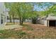Fenced backyard featuring a storage shed, trees, small patio, and plenty of green space at 4845 Weathervane Dr, Alpharetta, GA 30022
