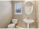 Bathroom featuring a pedestal sink, toilet, oval mirror, and window at 4845 Weathervane Dr, Alpharetta, GA 30022