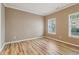Bright bedroom with hardwood floors, neutral paint, and ample natural light from two windows at 4845 Weathervane Dr, Alpharetta, GA 30022