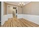Dining room featuring hardwood floors, chandelier, and traditional paneled walls at 4845 Weathervane Dr, Alpharetta, GA 30022