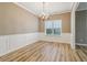 Well-lit dining room featuring a chandelier, hardwood floors, and view of the backyard at 4845 Weathervane Dr, Alpharetta, GA 30022