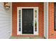 Close-up of the home's front door, framed by sidelights and brick accents, offering a welcoming entrance at 4845 Weathervane Dr, Alpharetta, GA 30022