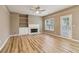 Open-concept living room featuring hardwood floors, fireplace, built-in shelving, and door to patio at 4845 Weathervane Dr, Alpharetta, GA 30022