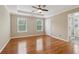 A main bedroom featuring hardwood floors, ceiling fan, and a tray ceiling at 4845 Weathervane Dr, Alpharetta, GA 30022