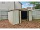Metal storage shed in a fenced backyard with a dirt floor and sliding doors at 4845 Weathervane Dr, Alpharetta, GA 30022