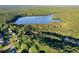 An expansive aerial view showcasing a lakefront community with lush trees, beautiful homes, and a stunning lake at 525 Sycamore Pt, Woodstock, GA 30189