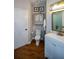 Cozy bathroom with white vanity, decorative mirror, and hardwood flooring at 525 Sycamore Pt, Woodstock, GA 30189