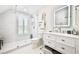 Bright bathroom with a glass enclosed shower, tiled floor, shuttered window and a floating vanity at 525 Sycamore Pt, Woodstock, GA 30189