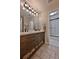 Bathroom featuring a wooden vanity with drawers, double sinks, modern lighting, and a view of the shower at 525 Sycamore Pt, Woodstock, GA 30189