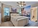Comfortable bedroom featuring a ceiling fan, a beautiful accent wall, and an adjacent bathroom at 525 Sycamore Pt, Woodstock, GA 30189