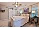 Comfortable bedroom featuring a ceiling fan, an accent wall painting, and a sliding barn door at 525 Sycamore Pt, Woodstock, GA 30189