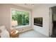 Cozy sitting area featuring a fireplace, large window with outdoor views, and access door at 525 Sycamore Pt, Woodstock, GA 30189