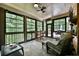 Inviting sunroom surrounded by trees, featuring wicker furniture, and a ceiling fan at 525 Sycamore Pt, Woodstock, GA 30189