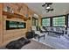 Cozy sunroom with wood walls, comfortable seating, fan, and an electric fireplace at 525 Sycamore Pt, Woodstock, GA 30189