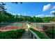 An inviting walkway leading to well-maintained tennis courts surrounded by mature trees, perfect for active residents at 525 Sycamore Pt, Woodstock, GA 30189