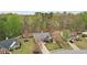 Aerial view featuring a brick home with well-manicured landscaping and a long driveway with mature trees and green lawns at 1145 Prospect Mill Dr, Lawrenceville, GA 30043