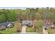 Aerial view of a brick home with a landscaped front yard and driveway, surrounded by lush trees and green lawns at 1145 Prospect Mill Dr, Lawrenceville, GA 30043