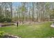 Lush backyard with mature trees, green lawn and mulched garden beds at 1145 Prospect Mill Dr, Lawrenceville, GA 30043