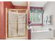 Bright bathroom features a shower with gold trim and a soaking tub under a window at 1145 Prospect Mill Dr, Lawrenceville, GA 30043