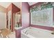 The bathroom has a garden tub with a window view and a separate shower with glass doors at 1145 Prospect Mill Dr, Lawrenceville, GA 30043