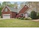 Charming brick home featuring an attached garage, well-maintained lawn, and a beautifully landscaped front yard at 1145 Prospect Mill Dr, Lawrenceville, GA 30043