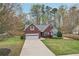 A charming brick home featuring an attached garage, long driveway, and a beautifully landscaped front yard at 1145 Prospect Mill Dr, Lawrenceville, GA 30043