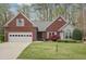 Charming brick home featuring an attached garage, manicured lawn, and a beautifully landscaped front yard at 1145 Prospect Mill Dr, Lawrenceville, GA 30043