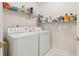Functional laundry room with a washer, dryer, and storage shelves at 1145 Prospect Mill Dr, Lawrenceville, GA 30043