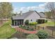 Backyard featuring a screened-in porch and meticulous landscaping with a red brick walkway around a gray colored house at 1145 Prospect Mill Dr, Lawrenceville, GA 30043
