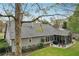 Rear exterior showcasing a screened-in porch, well-manicured lawn, and flower boxes on a gray house with a dark roof at 1145 Prospect Mill Dr, Lawrenceville, GA 30043