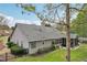 Well-maintained rear exterior featuring landscaping, a screened-in porch, and gray siding with a dark roof at 1145 Prospect Mill Dr, Lawrenceville, GA 30043