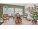 Cozy sunroom with large windows, wicker furniture, and bright green accent wall at 1145 Prospect Mill Dr, Lawrenceville, GA 30043