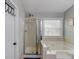 Bathroom boasting separate shower stall and soaking tub with a white tile surround at 2643 Herndon Nw Rd, Lawrenceville, GA 30043