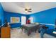 Bright bedroom with blue walls, ceiling fan, and a full size bed and desk setup at 416 Pine Log Ct, Canton, GA 30115
