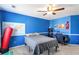 Blue bedroom featuring neutral carpet and fan with bed, side table and work area at 416 Pine Log Ct, Canton, GA 30115