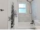 Bright bathroom features a shower and tub combination with lovely white and gray marble wall tiling and tree-themed shower curtain at 2742 Oakland Ter, Decatur, GA 30032